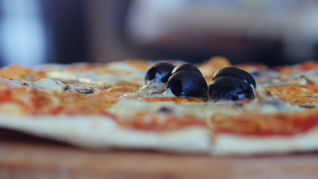 Close up of a pizza on the table. Restaurant on blurred backgroundの写真素材