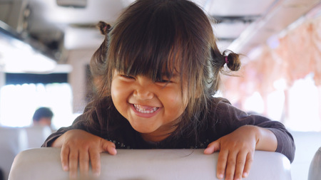Thailand, Bangkok, 22 december 2015. Child teasing a girl on the school bus. Happy asian girl has a fun timeのeditorial素材