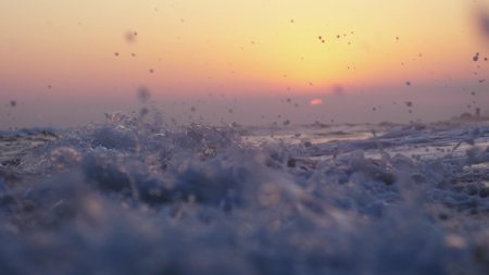 Waves at the beach in the evening at sunsetの写真素材