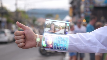 Businessman call the pretty wife who smiles and waves hand from the phone that appears in hologram futuristic clock. Augmented reality.の写真素材