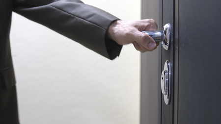 Closeup of male hand unlocks a houses doorの写真素材