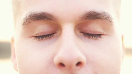 Close up of young man meditating with eyes closedの写真素材