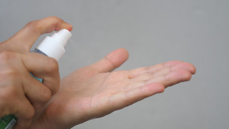 Female Uses Hand Sanitizer. Close up. Antiseptic spray protect from the virus.