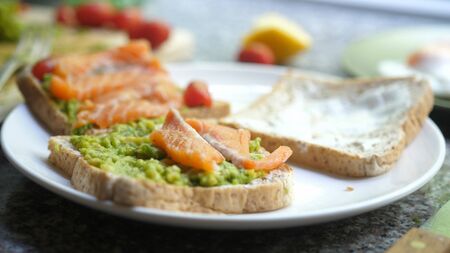 Cooking Toasts with avocado and smoked salmon on the white plateの写真素材