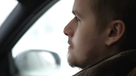 Young handsome man driving a car in winter