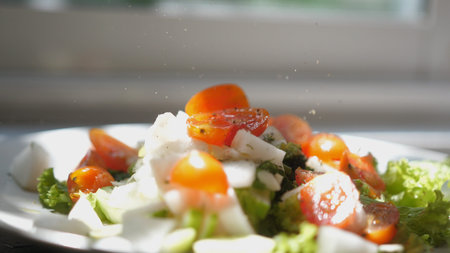Process of cooking, adding black powder pepper in vegetable salad