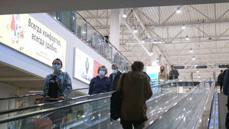 People on the escalator in medical masks. Adaptation of society to a pandemic of a viral infection COVID 19. Russia, Novosibirsk, 28 april 2020のeditorial素材