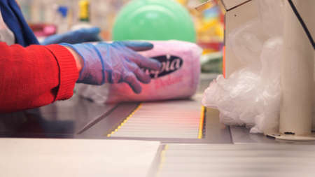 hands in gloves close-up. cashier in a supermarket registers goods. protective gloves for the coronavirus pandemic. Russia, Novosibirsk, 28 april 2020のeditorial素材