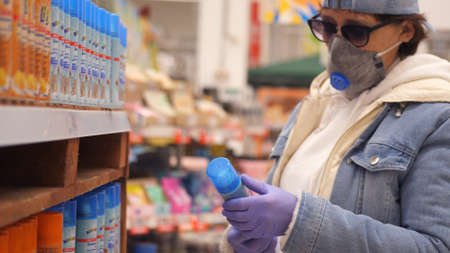 Old woman aged wearing medical Mask during coronavirus Shopping antiseptic Products At Supermarket. Concept of Covid-19 Quarantine. Russia, Novosibirsk, 28 april 2020のeditorial素材