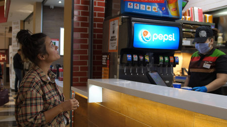 Young woman taking order at the fast food restaurant. Novosibirsk, Russia, 2020.