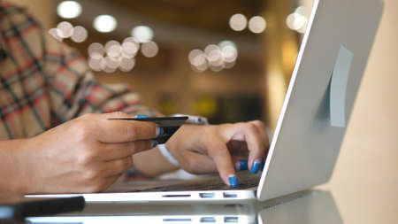 Female hands of cardholder holding credit card making e bank online payment. Woman consumer paying for purchase in web store using laptop technology. Ecommerce website payments concept.の写真素材