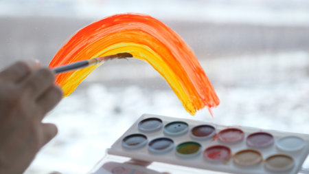 a womans hand painting rainbow during Covid-19 quarantine at home. Stay at home Social media...
