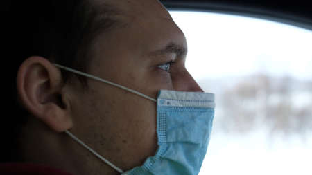 Man Traveling On Winter Automobile Road. Self Isolation On Car On Lockdown Quarantine. Man In Face Mask Driving Car On Lockdownの写真素材