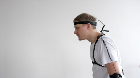 athletic man with beard wears motion capture suit with sensors headset moving in virtual reality...