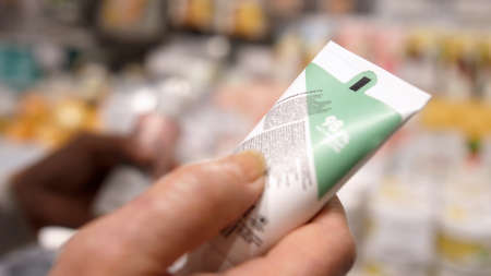 Female Customer Reading Label on Cosmetic Bottle In Supermarket.の写真素材