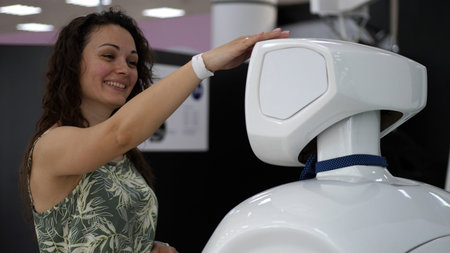 A cyborg and a young woman are cooperating each other. Woman touches a white cyborgの写真素材