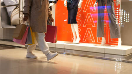 Young woman walking in centre mall with shopping bags. Close upの写真素材