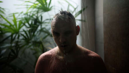 Young handsome man taking tropical shower. Shower in the private villa.の写真素材