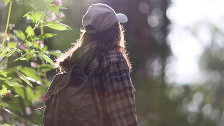 Young Caucasian woman with backpack traveling in the forest. The girl is feeling fresh, wonderful exciting and relax in nature wildの写真素材