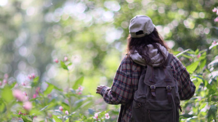 Young Caucasian woman with backpack traveling in the forest. The girl is feeling fresh, wonderful exciting and relax in nature wildの写真素材