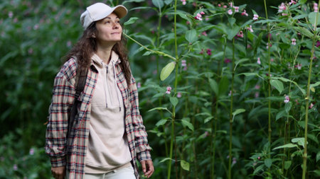 Young Caucasian woman with backpack traveling in the forest. The girl is feeling fresh, wonderful exciting and relax in nature wildの写真素材