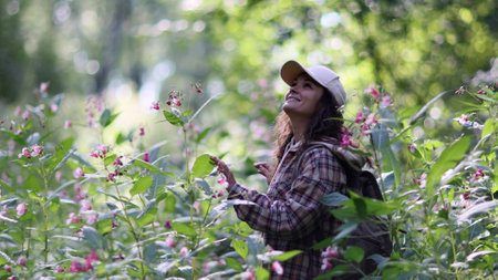 Young Caucasian woman with backpack traveling in the forest. The girl is feeling fresh, wonderful exciting and relax in nature wildの写真素材