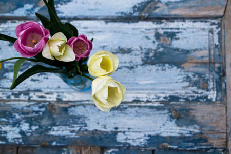 Bouquet of tulips in a vase on a wooden backgroundの写真素材