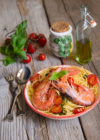 Italian spagetti with prawns, cherry tomatoes and basilの写真素材