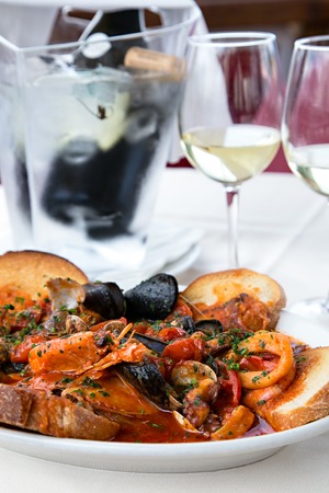 Vertical sea food tomatoes mediterranean soup with bread and white wineの写真素材