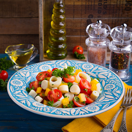 Fresh salad of heart of palm, cherry tomatoes, yellow bell pepper, garlic and parsley on wood backgroundの写真素材