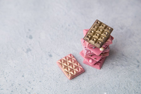 Broken pink Ruby chocolate bar pieces, made from ruby cocoa beans with gold, silver and white crisp