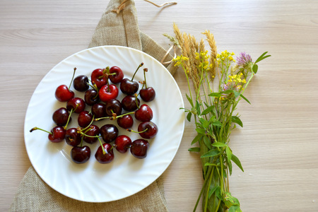 cherries and flowers on the tableの写真素材
