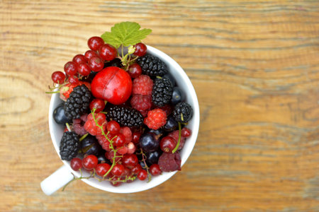 Fresh organic summer berries in a cup. Currant, raspberry, mulberry