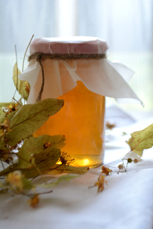 Honey in a transparent jar on the tableの写真素材