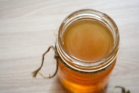 Honey in a transparent jar on the tableの写真素材