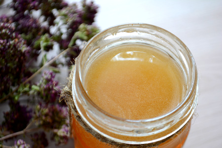 Honey in a transparent jar on the tableの写真素材