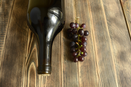 Autumn composition wine bottle grapes on a wooden background copy spaceの写真素材