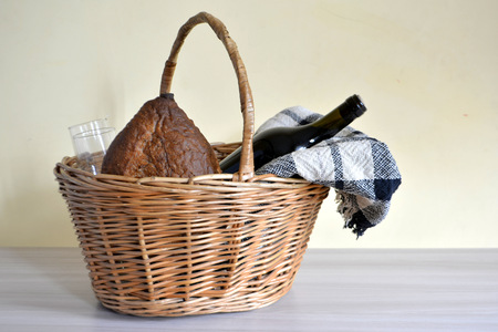 wicker picnic basket with a blanket, bottle of wine, bread and glassesの写真素材