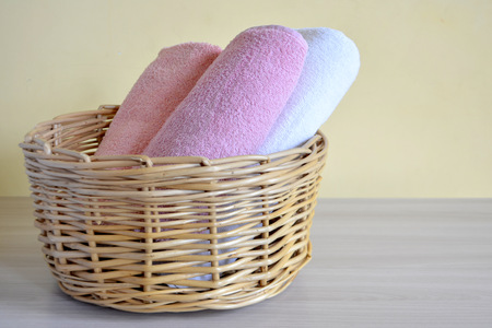 Wicker basket with towels on a light backgroundの写真素材