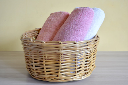 Wicker basket with towels on a light backgroundの写真素材