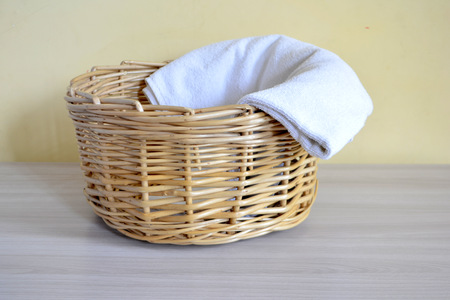 Wicker basket with towels on a light backgroundの写真素材