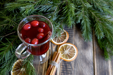 Christmas mulled wine with cranberries in glass. Winter warming drink with spices. Decorated with fir branches cinnamon dried orangesの写真素材