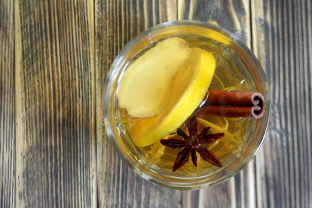 Ginger drink with lemon and spices. Ginger tea on wooden table. Top view. Copy spaceの写真素材