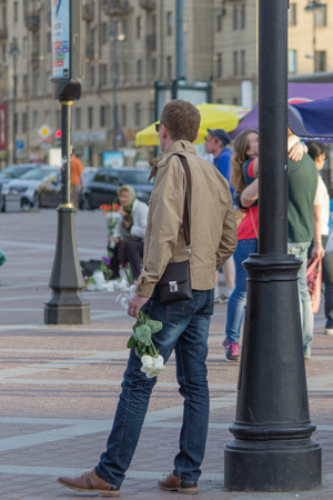 a man stands with flowers in anticipation bye a man stands with flowers in anticipation bye