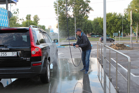 Russia, Penza - June 25, 2017: a man washes his car on a contactless wash self-serviceのeditorial素材