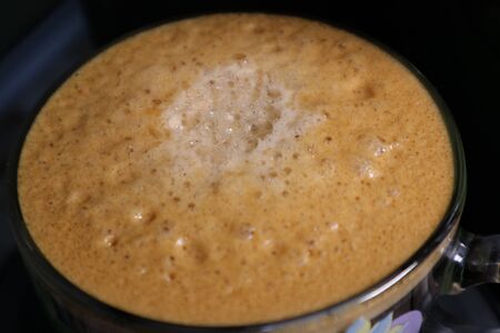thick foam of fragrant fresh coffee brewed in the coffee makerの写真素材