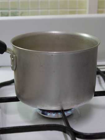 view of the aluminum bucket standing on the gas stoveの写真素材