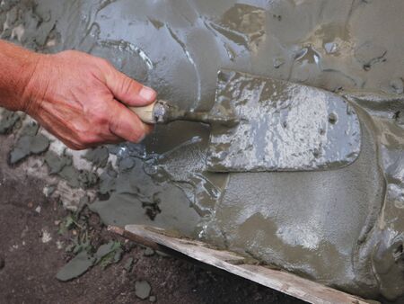 laying a layer of cement with a construction trowelの写真素材
