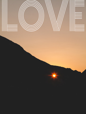 Sunset through the heart shaped hole in the cliffの写真素材