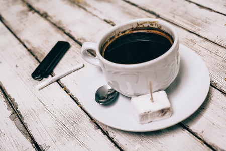 Cup of coffee with cigarette on the wooden tableの写真素材